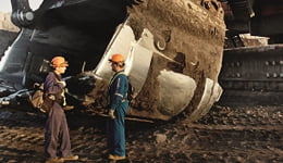 Dos personas frente a equipos mineros